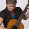 Photo of Sister Dorothy, in casual wear, with acoustic guitar